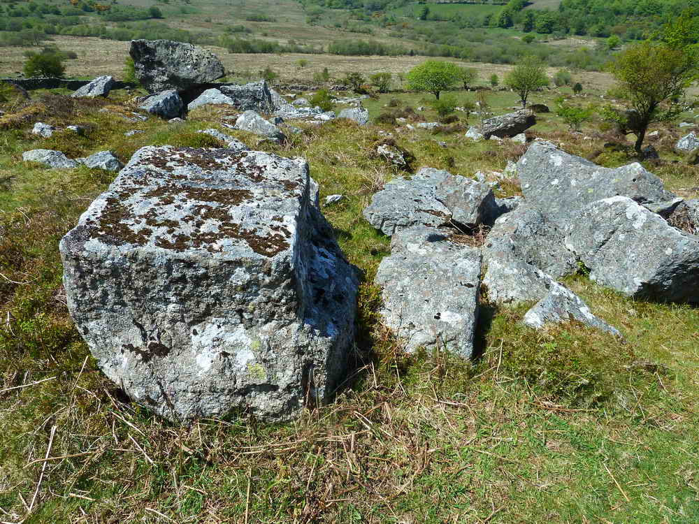 A collection of worked or semi-worked pieces of granite, including a section of tramway rail (at right)