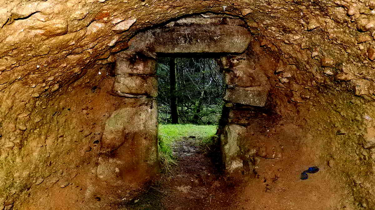 Flash photograph inside the cave looking out. Note the granite door jambs and lintel, with a gate hanger visible in the left jamb