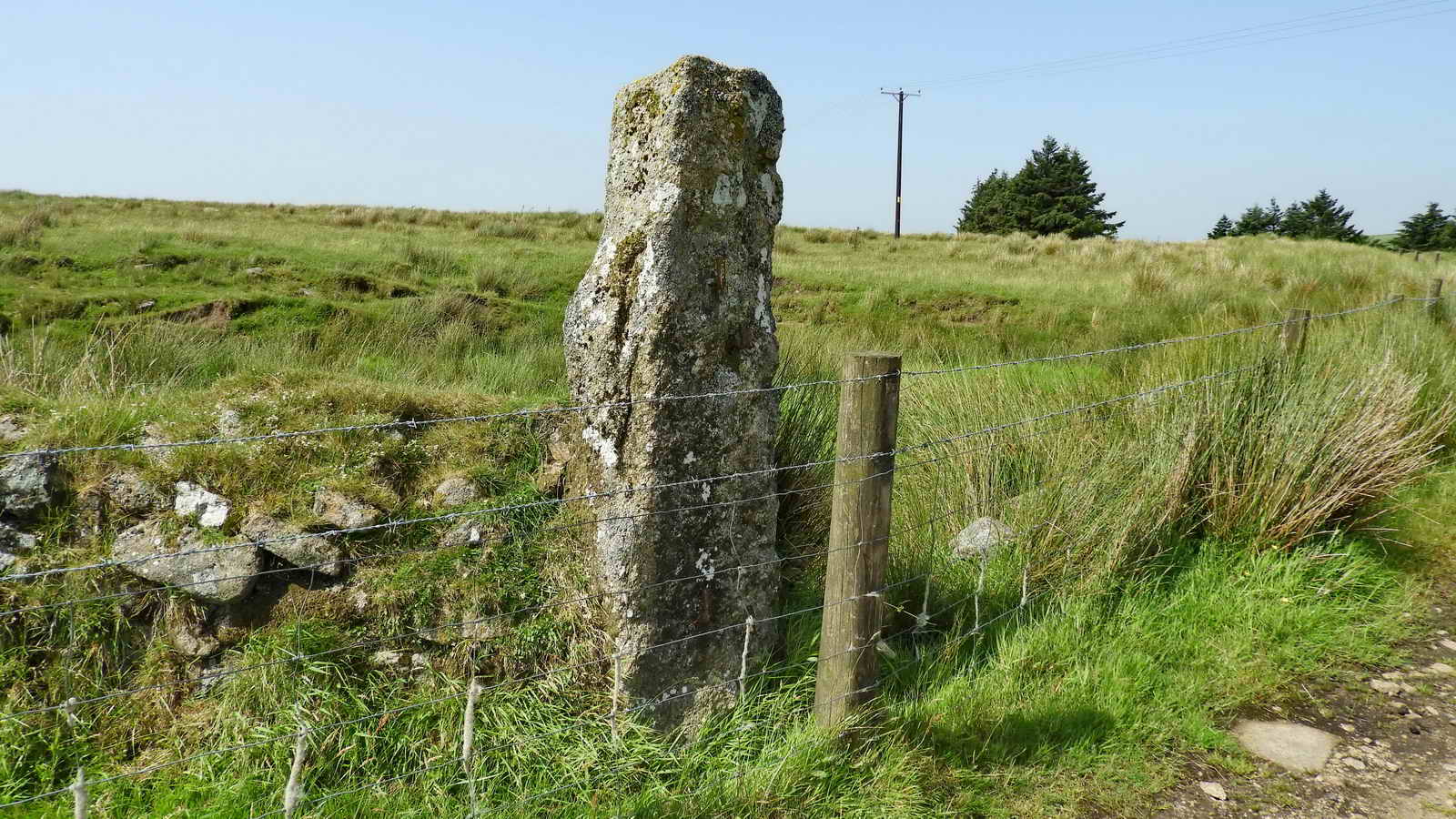 A massive stone gatepost with a pair of iron gate hangers